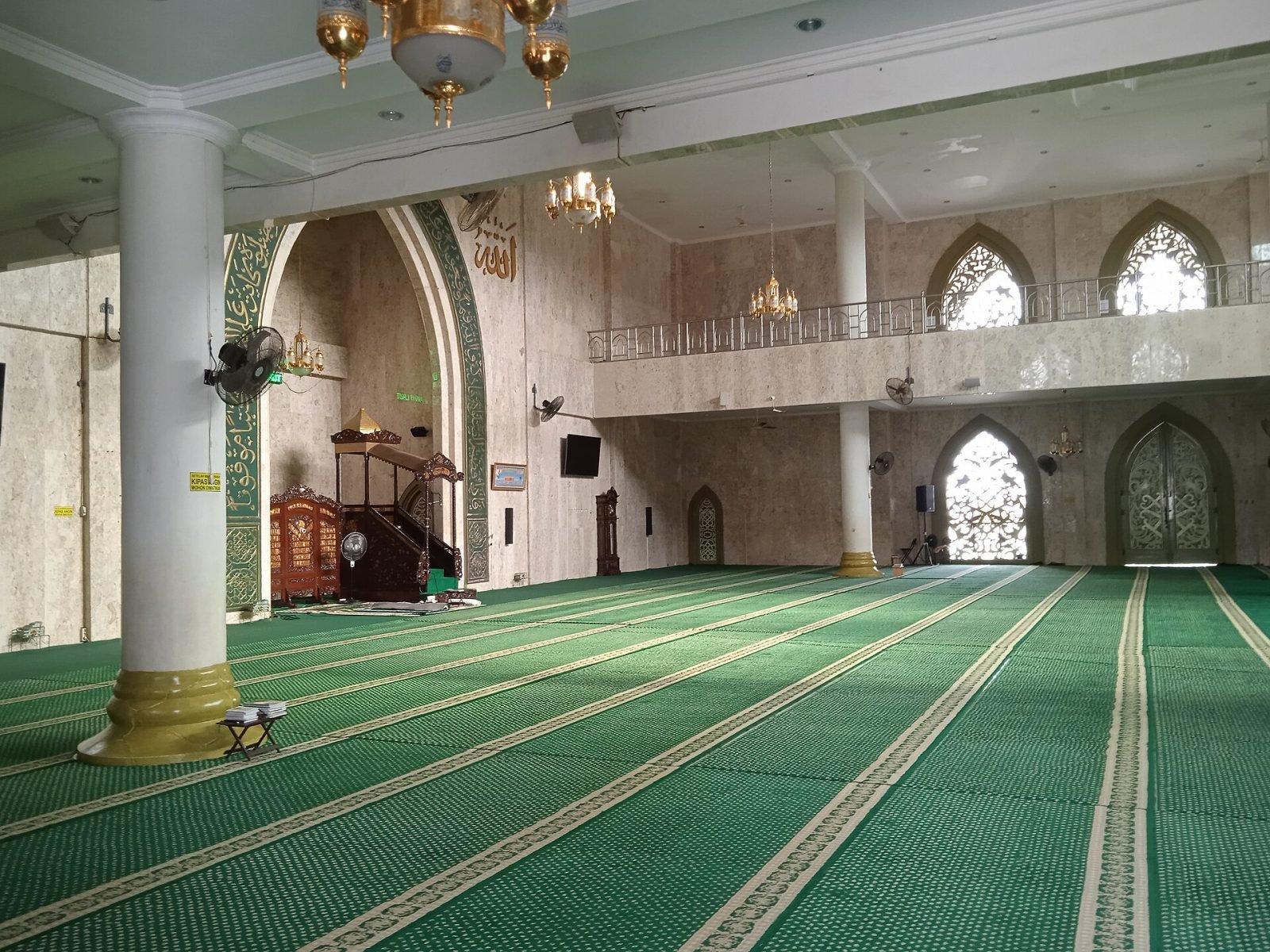 Ruang shalat masjid yang bersih dengan karpet hijau